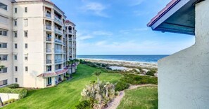 A hotel with multiple balconies overlooking a beach.