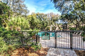 A gated entrance to a private pool area with a sign indicating it is a guest-only facility.