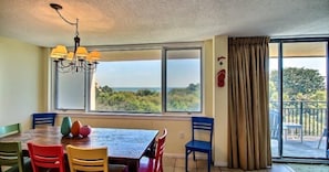 Enjoy a meal with a view of the lush landscape from this dining area, featuring a wooden table and unique chairs.