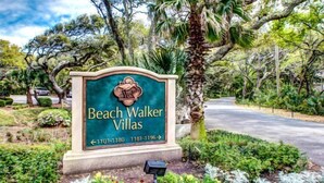 Schild für Beach Walker Villas mit Pfeilen und Kontaktnummern.