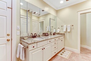 A bathroom with a double sink vanity, a large mirror, and a towel rack.