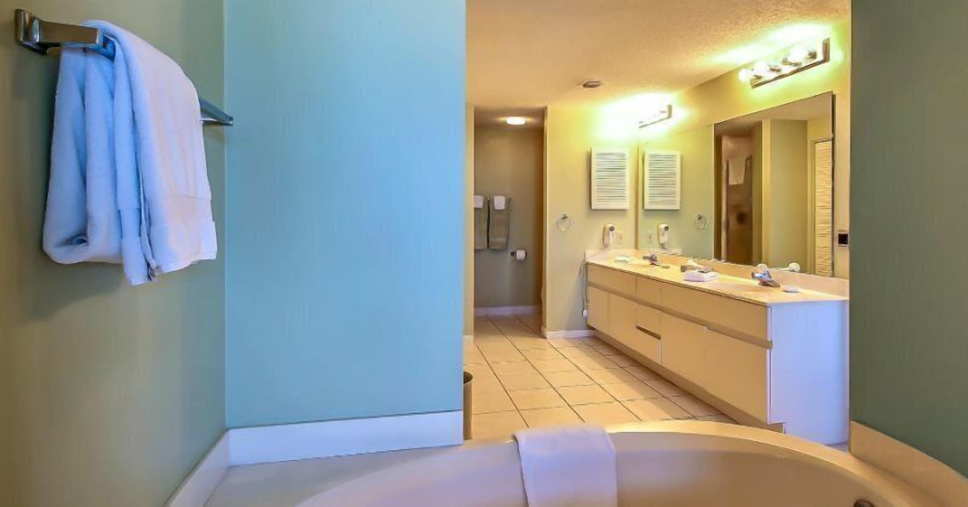 Une salle de bain avec une baignoire, un lavabo et un miroir.