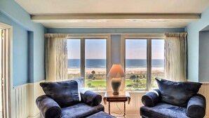A room with two leather armchairs facing a large window with a view of the beach. - 1354-shipwatch (Fernandina Beach)