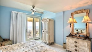A bedroom with a bed, a dresser, a mirror, and a ceiling fan. - 1354-shipwatch (Fernandina Beach)