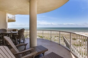 A covered outdoor area with a view of the beach, featuring lounge chairs and a table. - 60-ocean-place (Fernandina Beach)