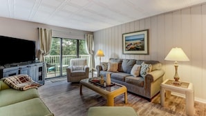 A living room with a television, sofa, armchair, and a coffee table. - 2081-beachwood (Fernandina Beach)