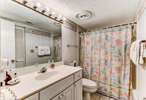 Un baño con lavamanos, espejo y retrete.