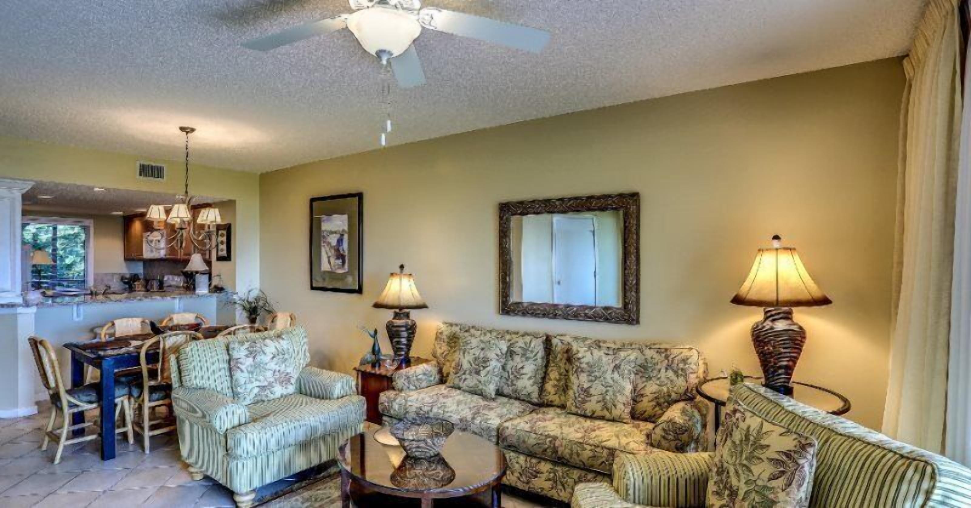 A living room with a sofa, chairs, a coffee table, and a dining area with a table and chairs.