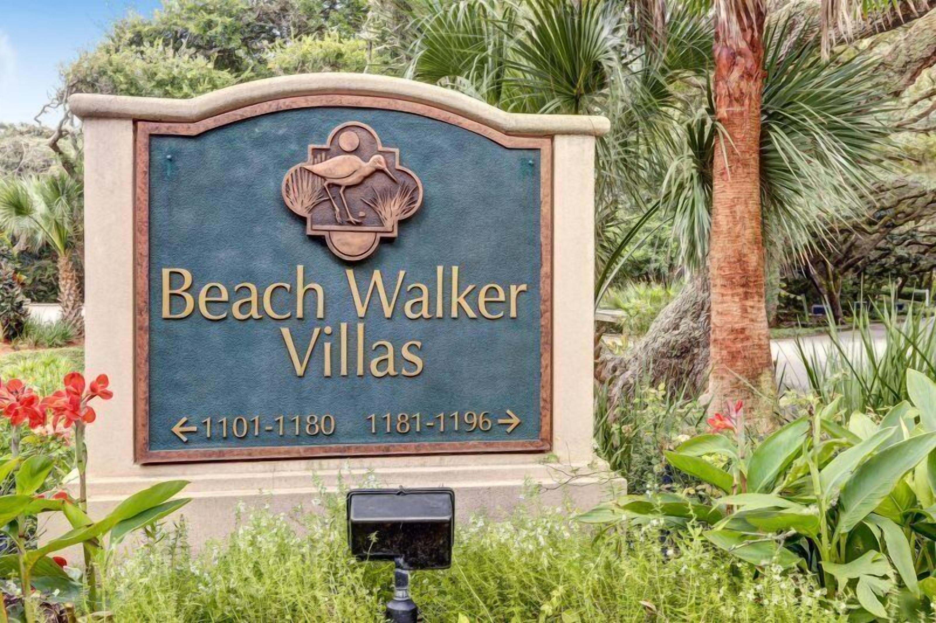 A sign for Beach Walker Villas with directional arrows and phone numbers.