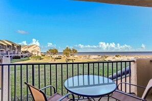 Enjoy the ocean view from this balcony with a round table and four chairs.