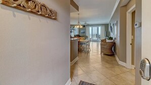 Un pasillo amplio con comedor, cocina y un elemento decorativo en la pared.