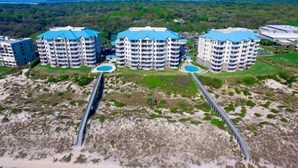 A coastal hotel complex with multiple high-rise buildings, each featuring balconies and a central swimming pool. - 57-ocean-place (Fernandina Beach)