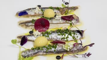 Plat amb peix, verdures i guarniments sobre un plat blanc.