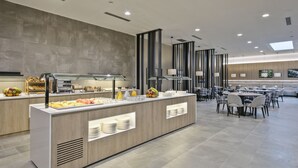 Un moderno comedor con estación de buffet, zona de estar y un amplio ventanal que proporciona luz natural.