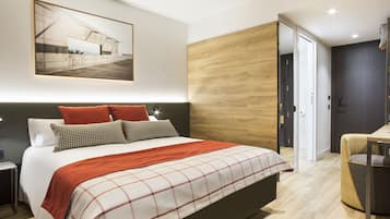 Un dormitorio moderno con una cama grande, un cabecero de madera y un cuadro enmarcado sobre la cama.