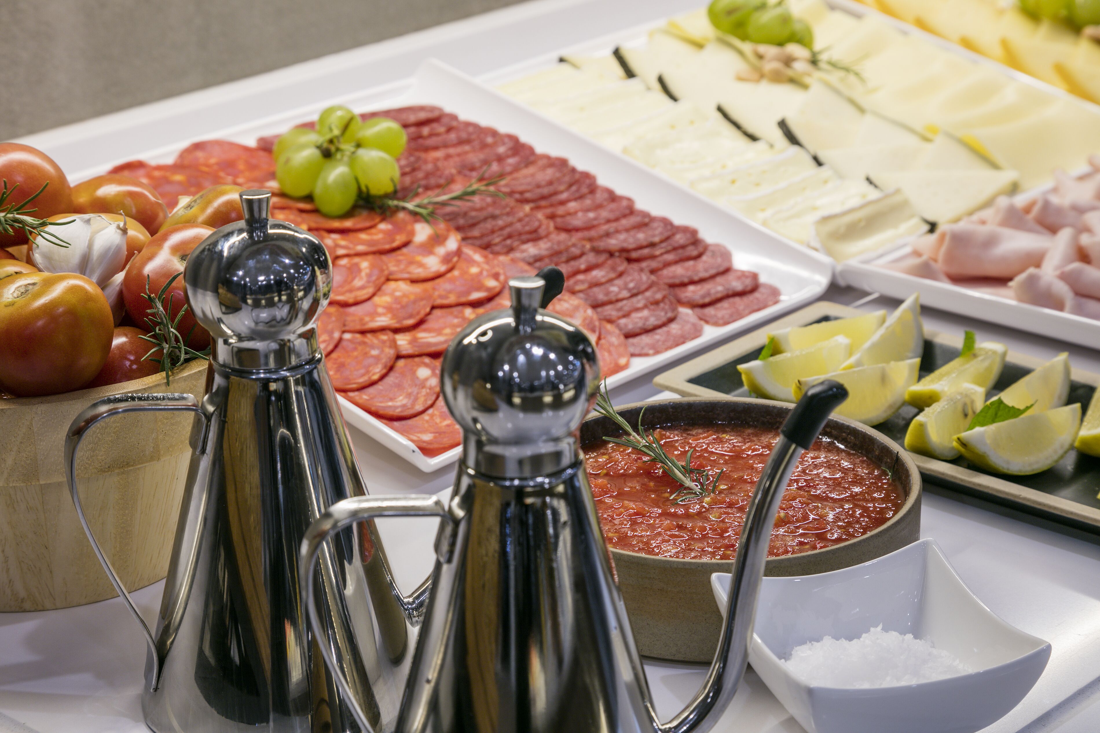 A buffet with various food items including sliced meats, cheeses, and vegetables.