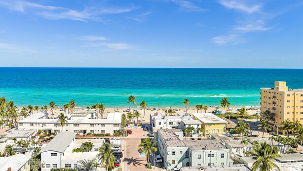 A coastal town with buildings, a beach, and the ocean. - The Palms (Hollywood)