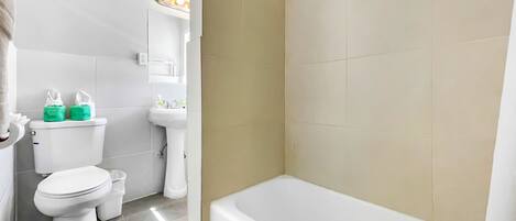 A bathroom with a toilet, sink, and bathtub.