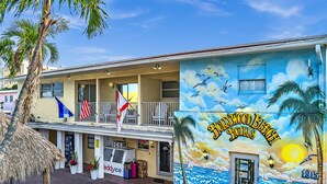 A two-story building with a mural of a beach scene and the Hollywood Beach Hotels name. - The Palms (Hollywood)