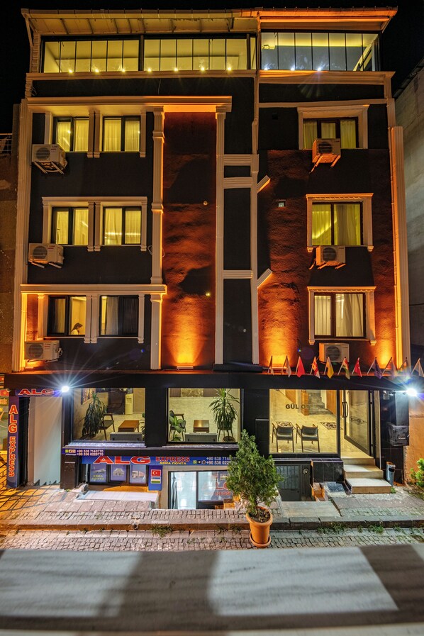 A multi-story hotel with balconies, air conditioning units, and a restaurant at the ground level. - Gul Otel (Istanbul)