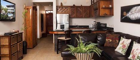 A modern kitchen with wooden cabinets, a refrigerator, and a dining area.