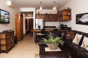 Enjoy a spacious living area with a central kitchen, dining space, and comfortable seating.