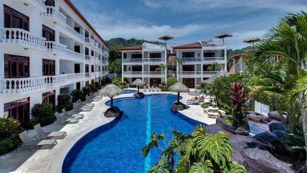 A resort with a central swimming pool, multiple balconies, and tropical landscaping. - Lpb-2d (Jacó)