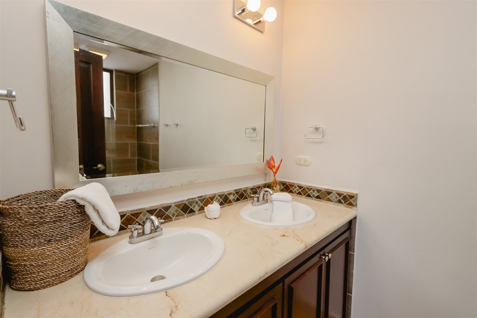 A bathroom with two sinks, a large mirror, and a towel rack.