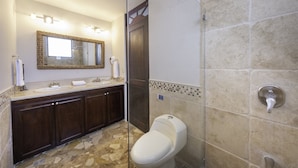 A bathroom with a double sink vanity, a large mirror, a toilet, and a shower area. - Amazing Seaside Penthouse With Rooftop Terrace (Jacó)