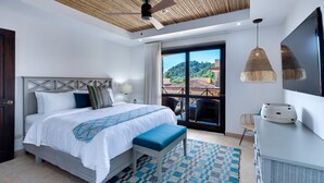 Ein modernes Schlafzimmer mit Bett, Schreibtisch und Blick ins Freie.