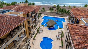 A resort with a central swimming pool, a smaller pool, and a beach view. - 5th Flr Ocean View Penthouse With 2 Level Balcony (Jacó)