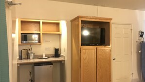 A compact kitchen with a microwave, coffee maker, and dishwasher. - Sunrise Inn Turlock (Turlock)