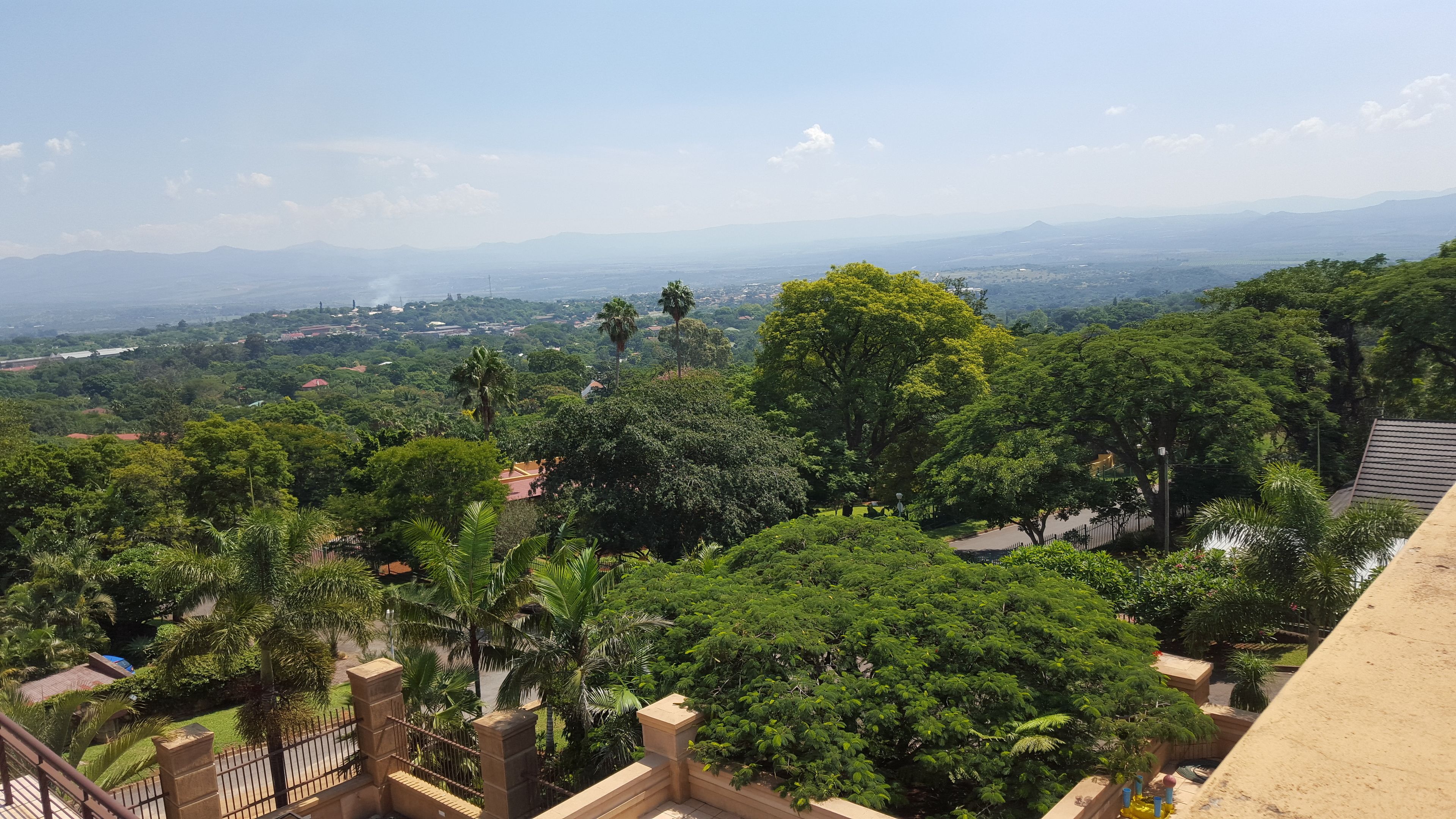 A lush green landscape with a view of distant mountains and a clear sky.