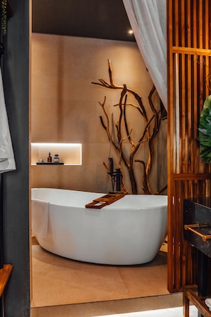 A modern bathroom with a freestanding bathtub, wooden wall decor, and a shelf with toiletries.