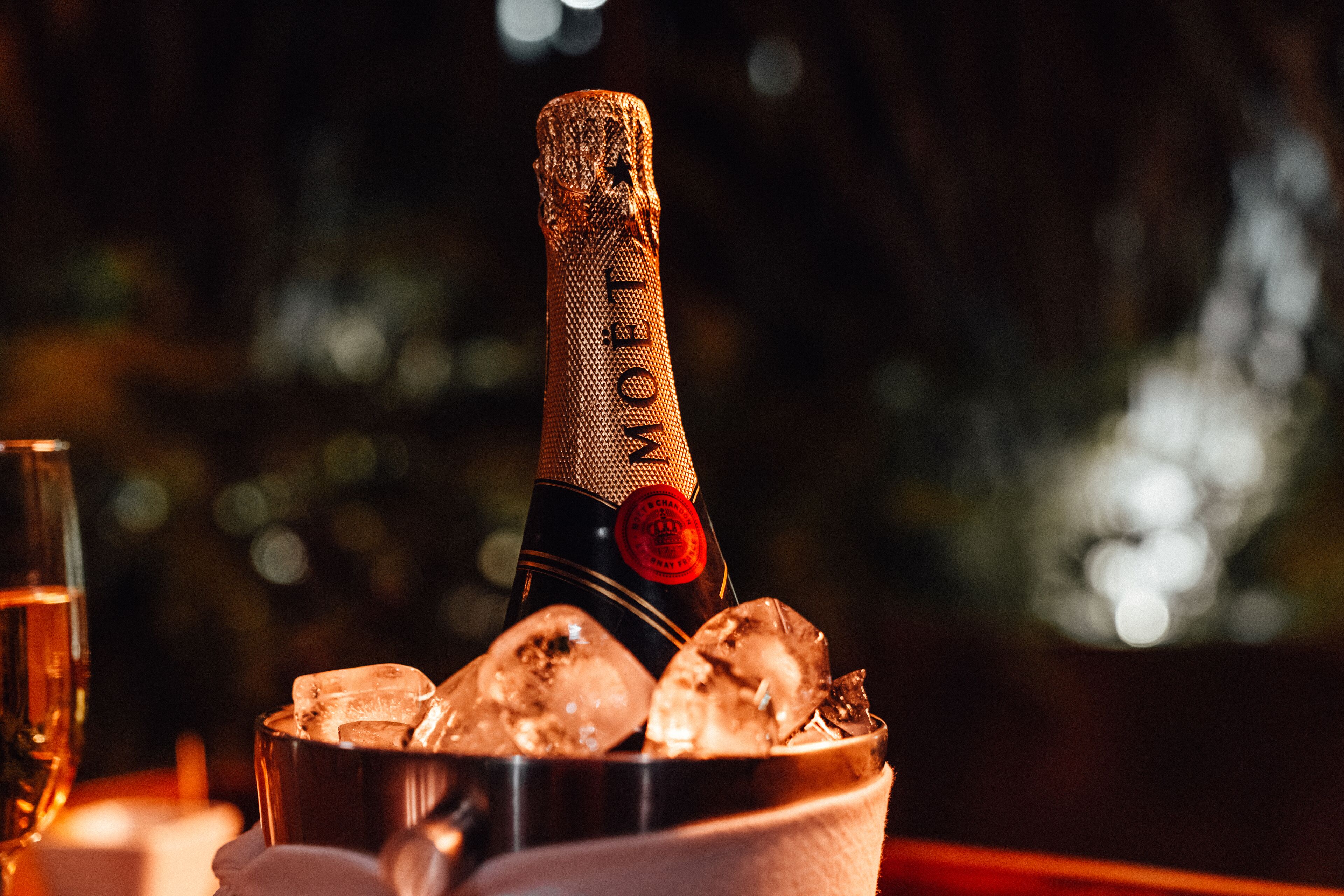 Une bouteille de champagne avec des glaçons dans un récipient en métal.