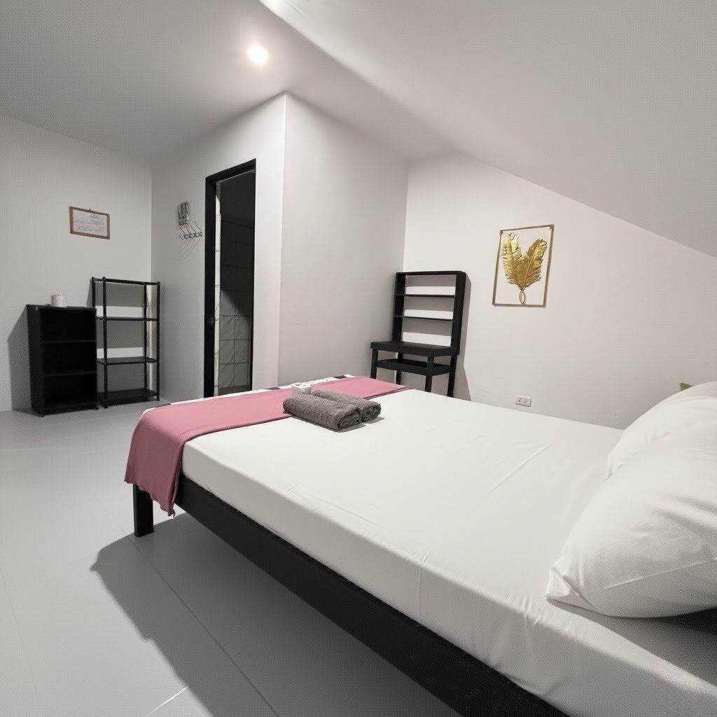 Un dormitorio con una cama, una silla, un escritorio y una estantería.