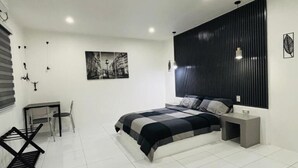 A modern bedroom with a large bed, a desk, and a chair. - Hotel Sisters Inn  Moalboal (Moalboal)