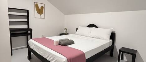 A bedroom with a bed, a chair, a nightstand, and a small table.