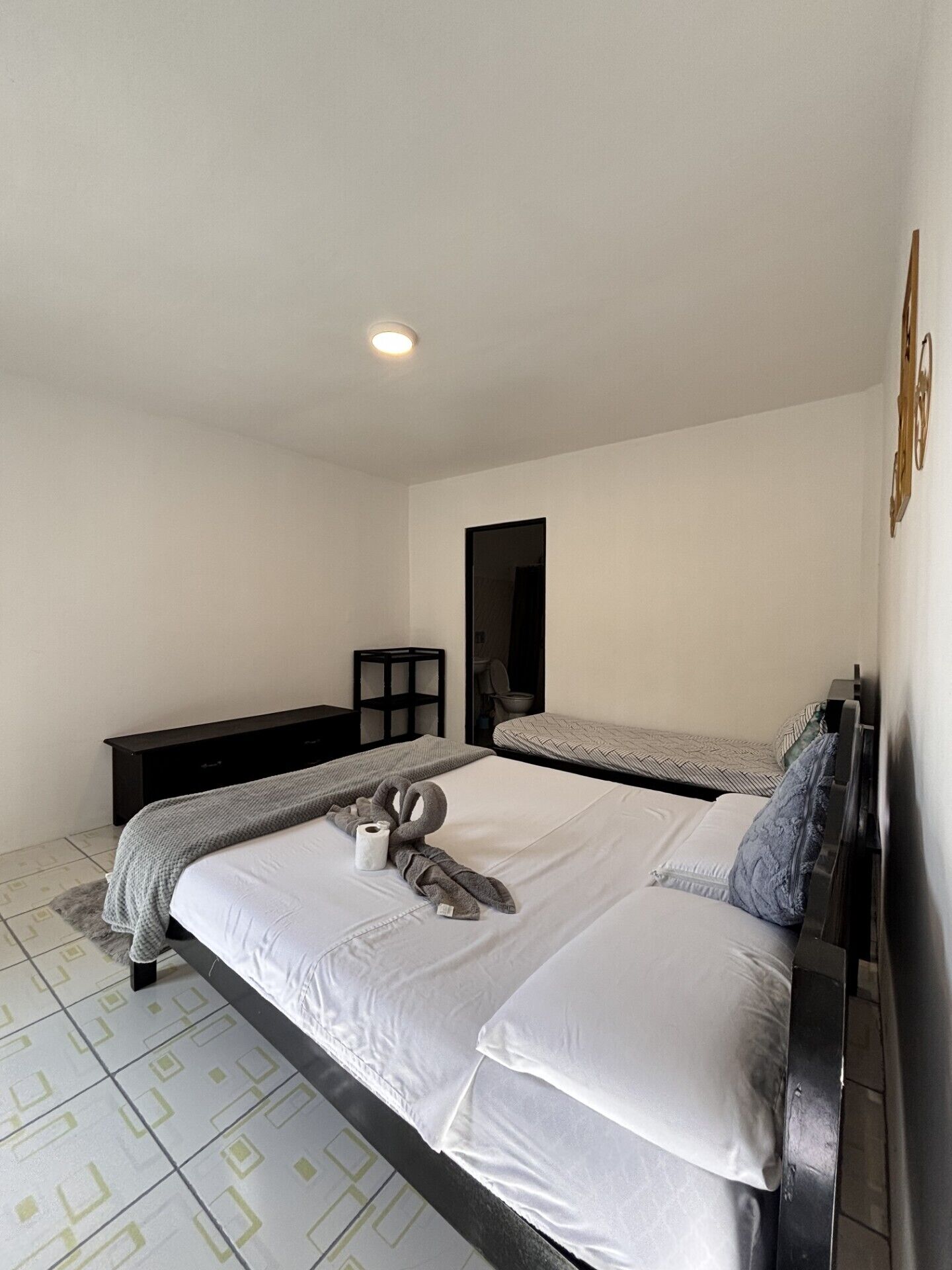 Ein Schlafzimmer mit einem großen Bett, einem Nachttisch, einer Kommode und einem Spiegel an der Wand.
