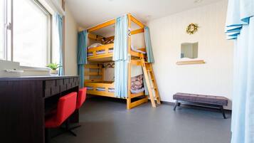 Un lit superposé avec un bureau et des chaises, un banc et un petit miroir accroché au mur.