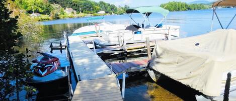 Un muelle con barcos, un jet ski y una zona cubierta.