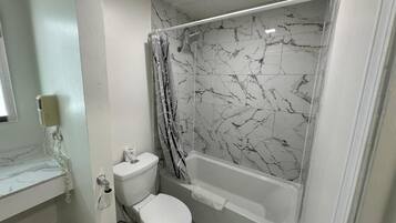 A bathroom with a toilet, bathtub, and shower curtain.