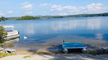A calm lake with a dock and a small boat.