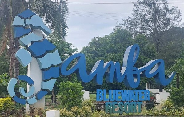 Letrero del Resort Bluewater con un diseño estilizado de las letras 'a' y 'm'.