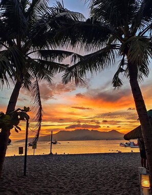 A beach with palm trees and a sunset. - Samba Bluewater Resort (Olongapo)
