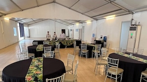 A large indoor space with multiple round tables covered with black tablecloths and white chairs. - Samba Bluewater Resort (Olongapo)