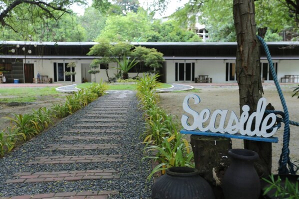 A pathway leading to a building with a 'Seaside' sign, surrounded by greenery and potted plants. - Samba Bluewater Resort (Olongapo)