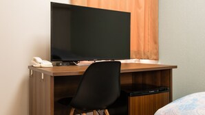 A hotel room with a wooden desk, a black chair, a Sony TV, a telephone, and a minibar. - Yokohama Sakuragicho Town Hotel 24 (Yokohama)