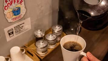 A hand pouring coffee into a white mug.