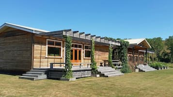 A wooden cabin with a porch, steps, and a small garden area.